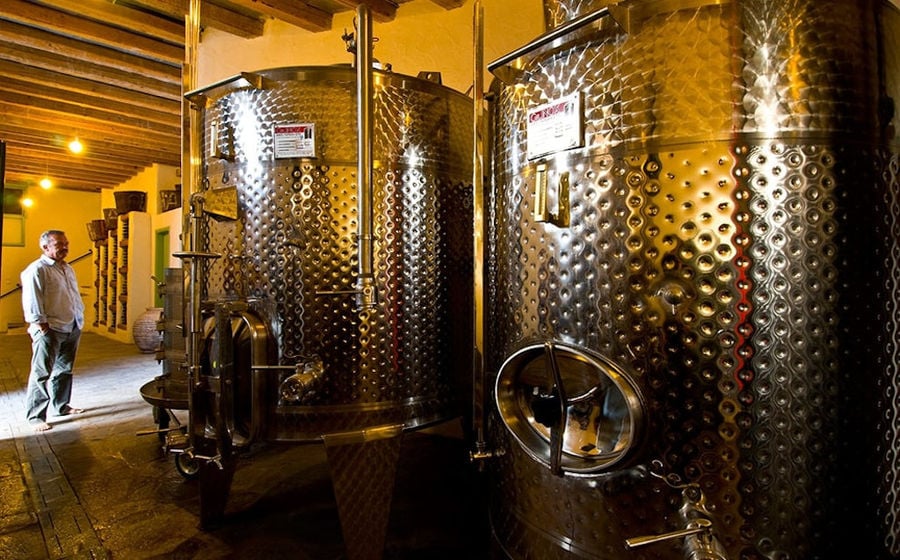 man in front the aluminum wine storage tanks at 'Manalis Winery' facilities